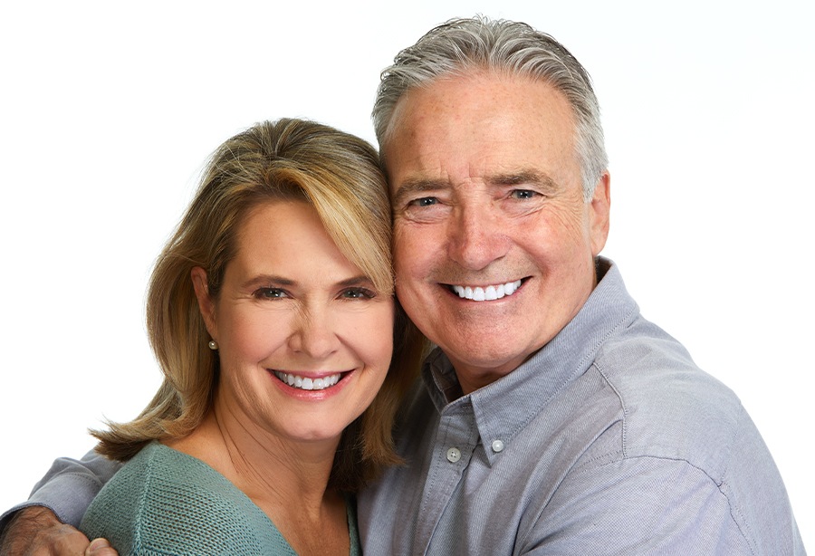 Man and woman smiling after dental laser implantology and endodontics treatment