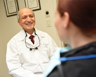 Doctor Makadia smiling at dental patient