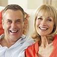 Husband and wife smiling bright after dental crowns and fixed bridges