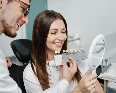 Happy dental patient holding mirror    