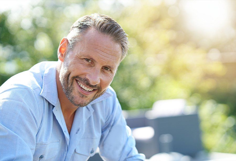 Man smiling after tooth replacement with dental implants