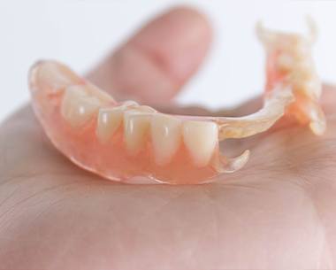 Hand holding a partial denture