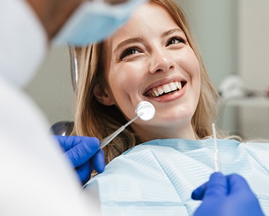 Woman smiling at dentist during family dentistry visit