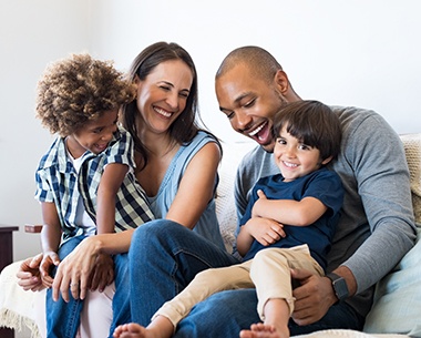 Mother father and two children laughing together after family dentistry visit