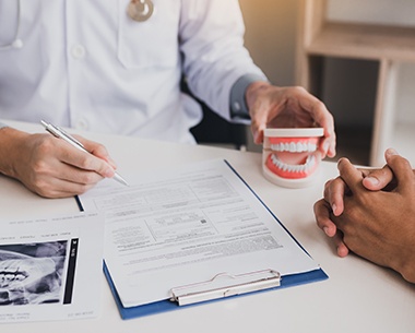 Dentist and patient reviewing dental insurance forms