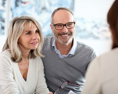 Man and woman discussing the cost of dental implant retained dentures