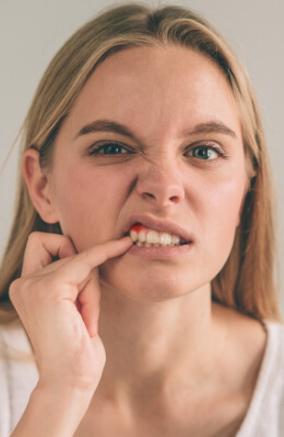 Woman pointing to her bleeding gums