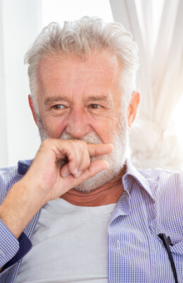 Senior man hiding his mouth with his hand