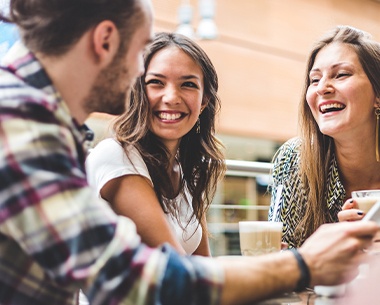 Group of friends laughing together after laser crown lengthening