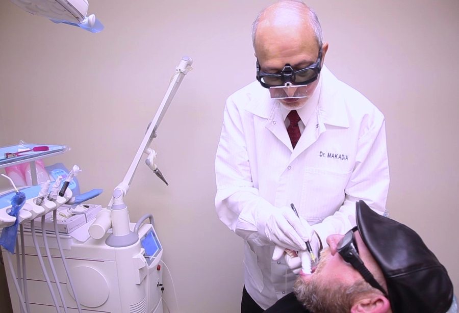 Dentist performing laser dentistry treatment
