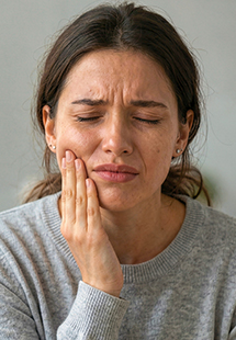 man holding his cheek in pain
