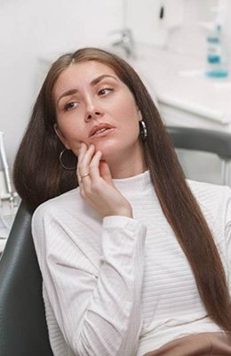 Patient holding cheek needing a root canal