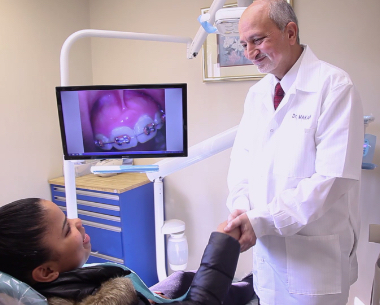 Doctor Makadia shaking hands with dental patient