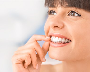 Woman placing an Invisalign tray