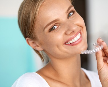 Woman placing a SureSmile clear aligner tray