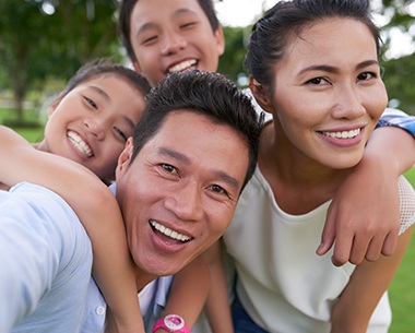 Mother father and two children smiling after family dentistry visit