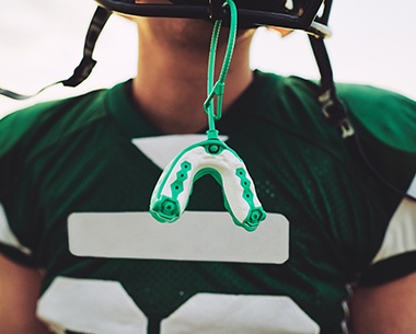 Athletic mouthguard hanging from football helmet