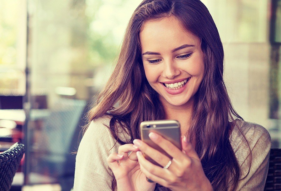 Young woman using smartphone to request a dental appointment