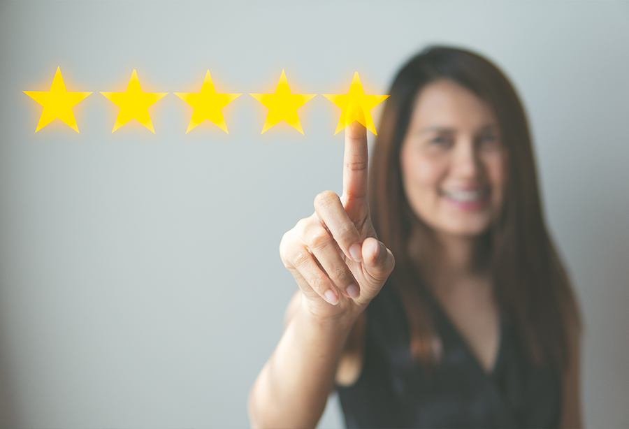 Woman choosing five stars to rate her dental office