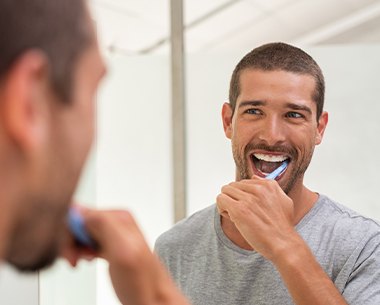 Man brushing teeth to maintain oral hygiene after a root canal