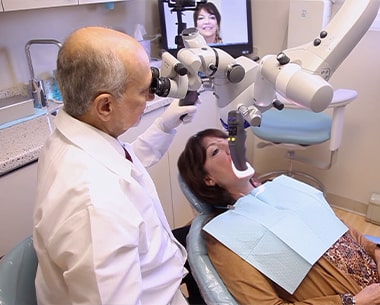 Dentist using dental microscope
