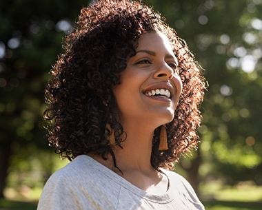 Woman sharing healthy smile after tooth colored filling restoration