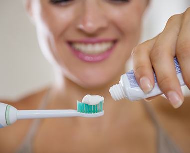Woman brushing teeth to protect her smile