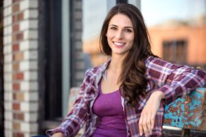 Woman with perfect teeth relaxing on outdoor bench