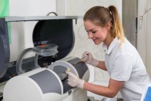 Dental team member operating CEREC machine