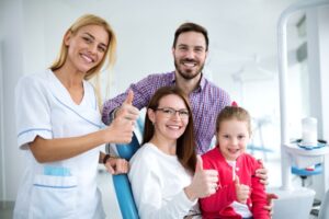 Happy family posing with dental team member