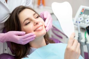 Cosmetic dentistry patient admiring her smile in the mirror