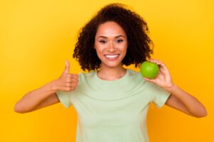 Smiling woman holding a green apple